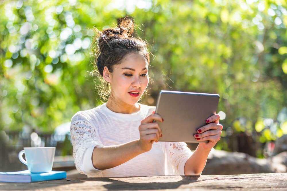 Happy woman playing lottery on her tablet