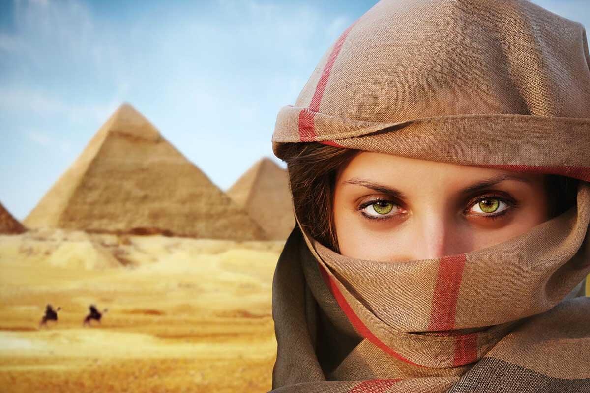 Beautiful green-eyed woman in chador and the pyramids.